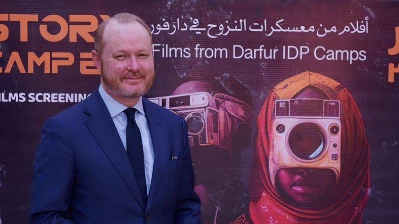 السفير الأمريكي مع لوحة اعلان الفيلم